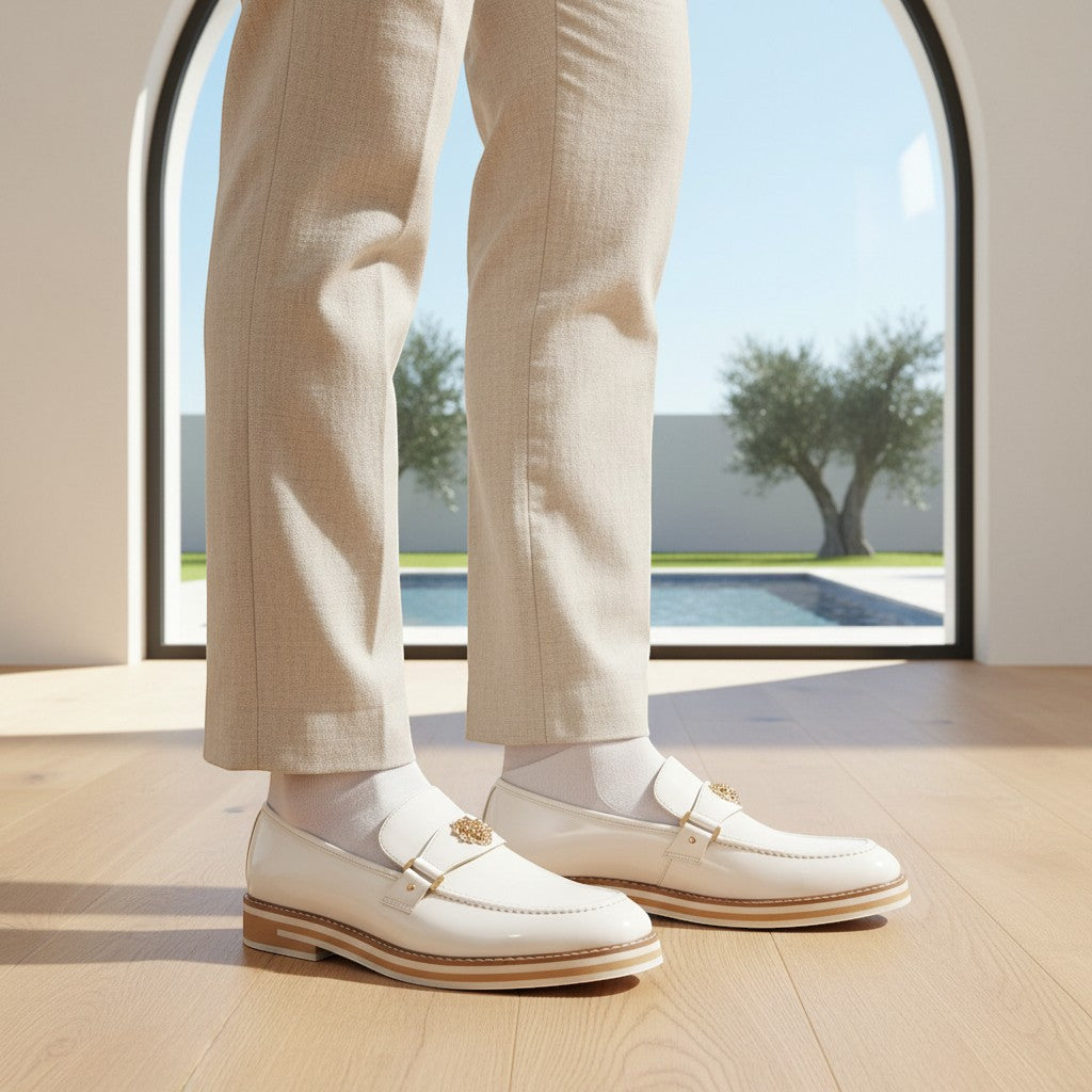 The City Warehouse-Menswear Ashford white leather moc-toe slip-on loafers worn with beige trousers by a pool.