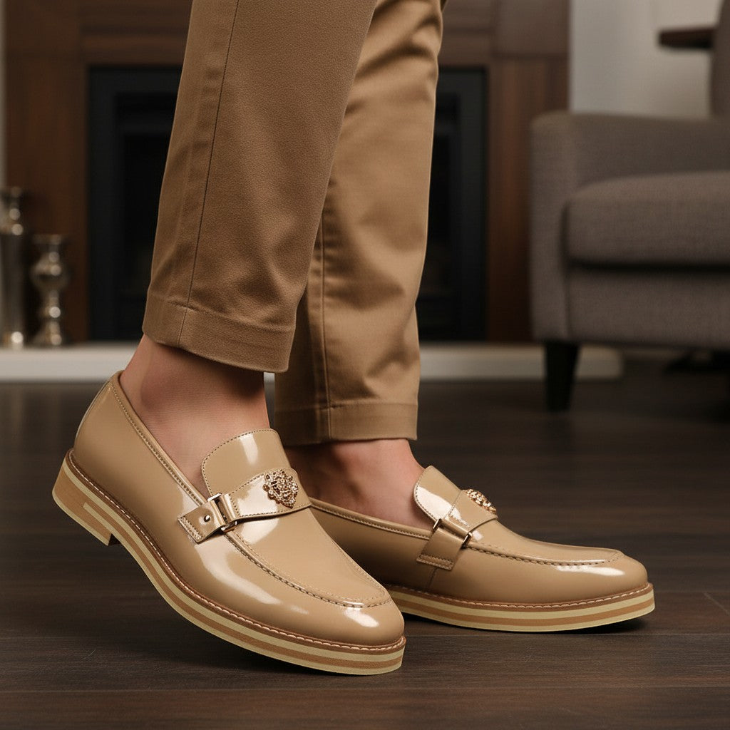 The City Warehouse-Menswear Ashford natural patent leather moc-toe loafers worn with tan trousers in a home setting.