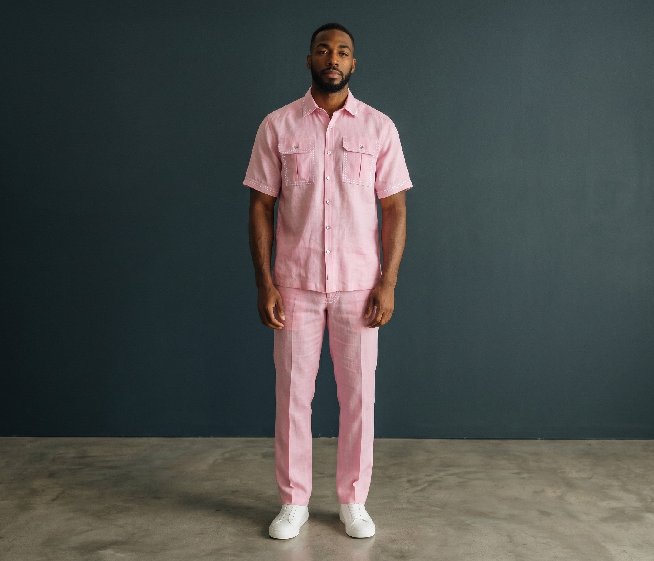 The City Warehouse-Menswear pink short-sleeve lace shirt and matching trousers set worn by a man with white sneakers.
