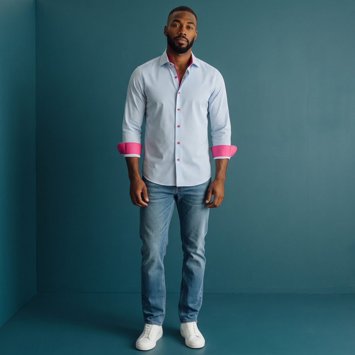 Model wearing a Steven Land light blue Bengal-striped cotton dress shirt with vibrant pink cuff and collar accents.