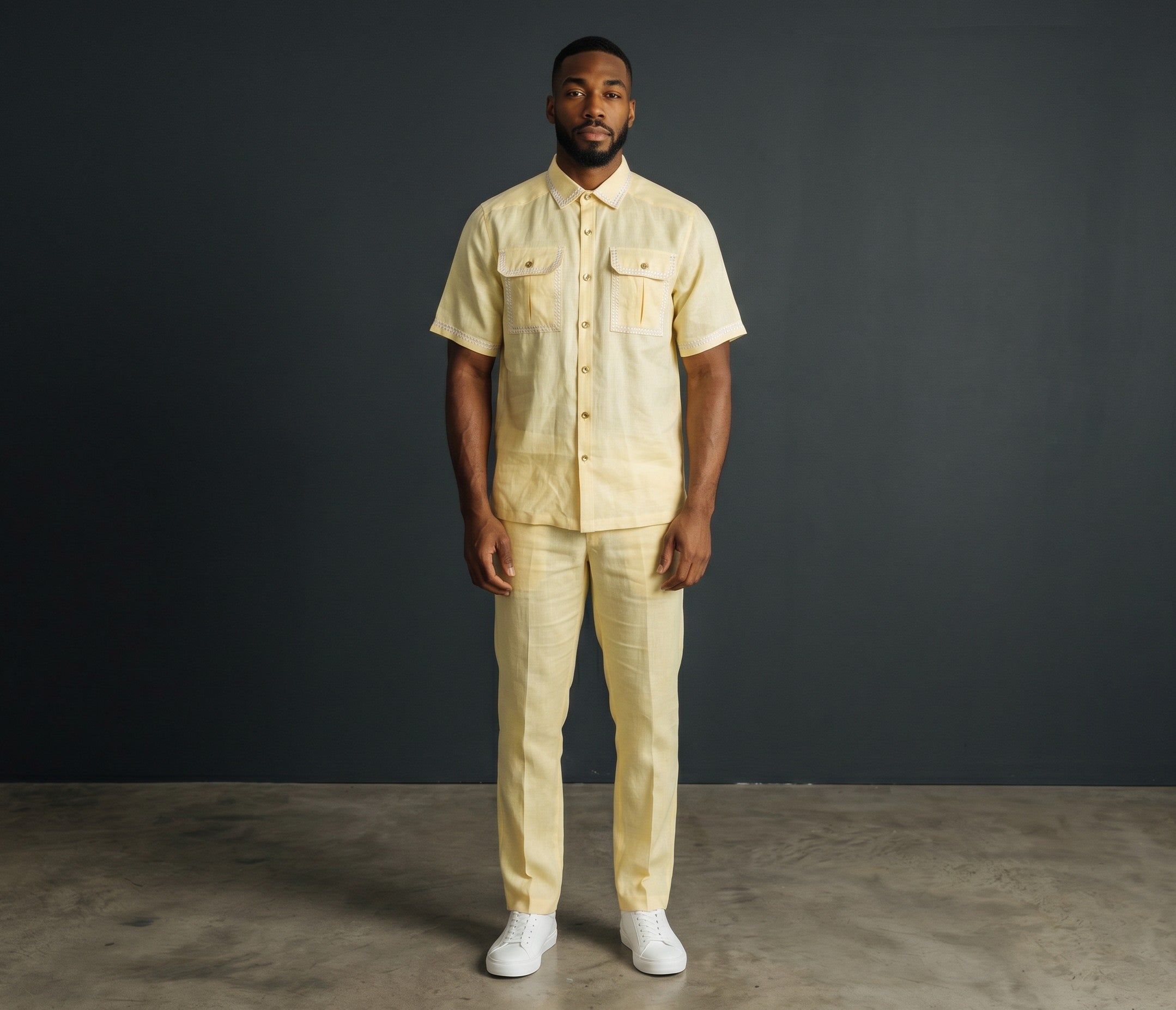 The City Warehouse-Menswear yellow short-sleeve lace shirt and matching trousers set worn by a man in a studio.
